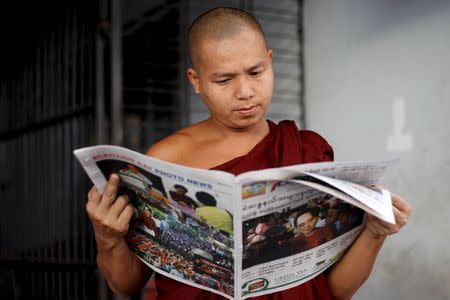 A Buddhist monk reads a newspaper on a street in Yangon November 9, 2015. REUTERS/Soe Zeya Tun