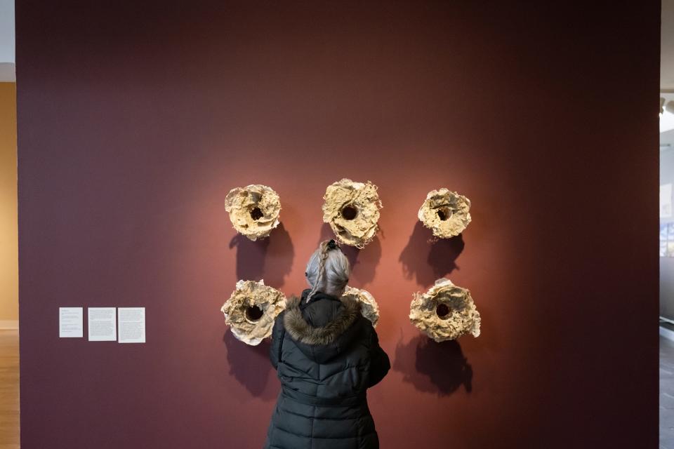 A guest views work by May Babcock, Rome Point Seaweed Constructions 2021,  currently on display as part of "Paper Town" at Fitchburg Art Museum on Sunday April 02, 2023.