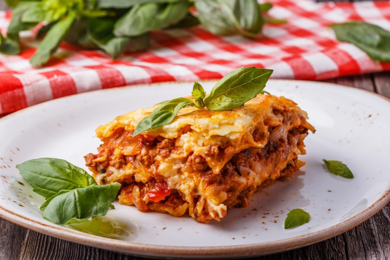 Traditional lasagna made with minced beef bolognese sauce and bechamel sauce  topped with basil leaves.