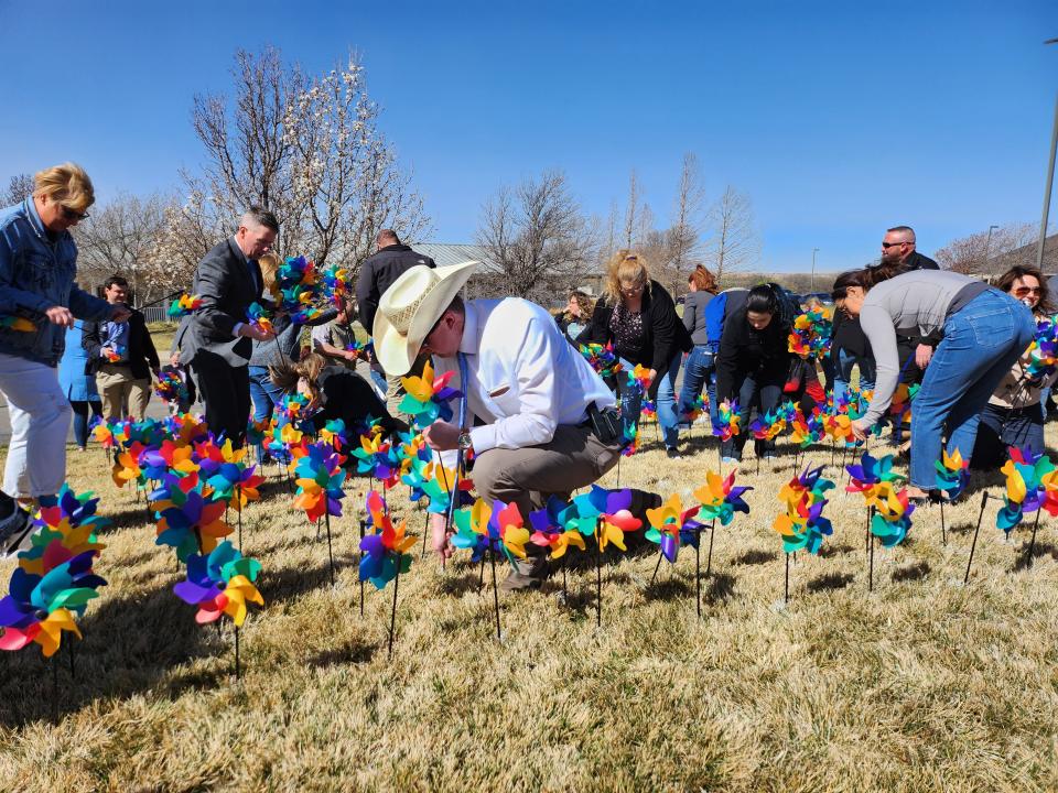 Friday morning, local organizations climbed the lawn in front of the Bridge Advocacy Center to plant brightly colored pinwheels, which will be spinning throughout the month of April in honor of every child who was interviewed by The Bridge staff in 2022.