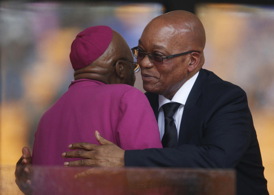 South African President Jacob Zuma, right, hugs Retired Anglican Archbishop Desmond Tutu during the memorial service for former South African president Nelson Mandela at the FNB Stadium in Soweto near Johannesburg, Tuesday, Dec. 10, 2013. (AP Photo/Matt Dunham)