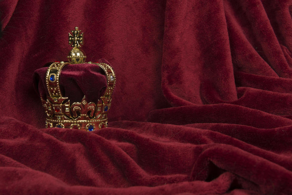 A crown sitting on a purple drape