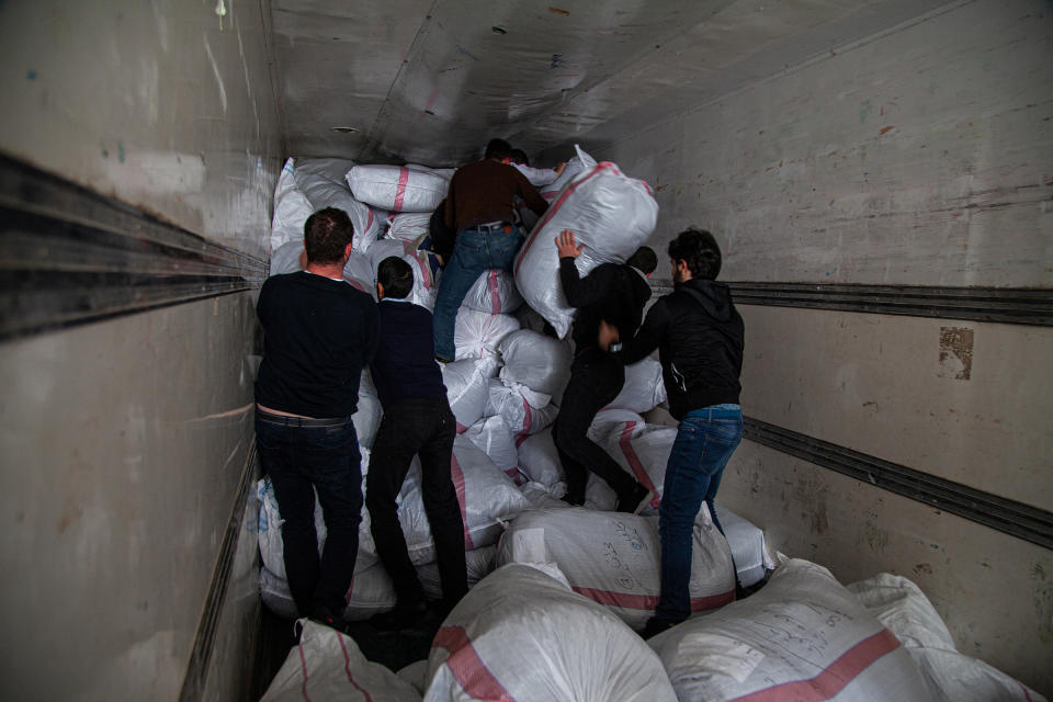 Men load sacks of humanitarian items into a truck in Gaziantep, Turkey, on Jan. 5, 2020. The aid was collected for newly displaced Syrians from Idlib. | Ahmad Al-islam—SOPA Images/Sipa USA