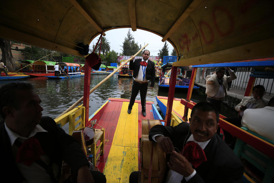 Groups of mariachis wait alongside a canal in hopes of selling their services to passengers on trajineras, the colorful boats typically rented by tourists, families, and groups of young people, in Xochimilco, Mexico City, Friday, Sept. 6, 2019. The usually festive Nativitas pier was subdued and largely empty Friday afternoon, with some boat operators and vendors estimating that business was down by 80% on the first weekend following the drowning death of a youth that was captured on cellphone video and seen widely in Mexico. Borough officials stood on the pier to inform visitors of new regulations that went into effect Friday limiting the consumption of alcohol, prohibiting the use of speakers and instructing visitors to remain seated.(AP Photo/Rebecca Blackwell)