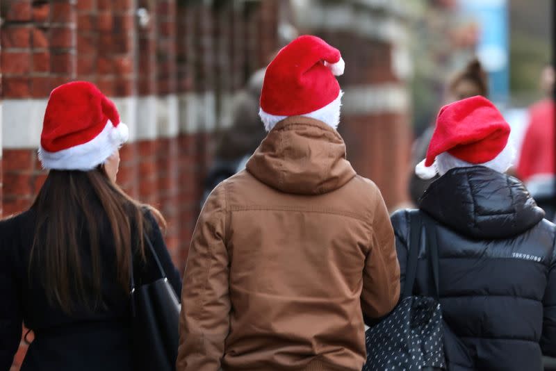 People wearing Christmas hats walk on Kings Road