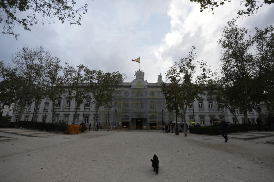 A dog walks outside the Supreme Court in Madrid, Spain, Monday, Oct. 14, 2019. Spain's Supreme Court is set to rule on a rebellion and sedition trial against a dozen Catalan politicians and activists who were key protagonists in Catalonia's Oct. 1, 2017, independence referendum. (AP Photo/Paul White)