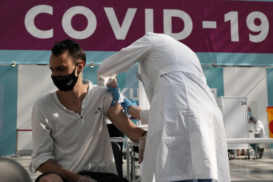 FILE - In this Monday, July 12, 2021 file photo, a medical worker administers a shot of Russia's Sputnik V coronavirus vaccine at a vaccination center in Gostinny Dvor, a huge exhibition place in Moscow, Russia. A senior Russian official says that the country has seen mortality rise at a faster pace last month amid a surge in coronavirus infections. Deputy Prime Minister Tatyana Golikova, who leads the government’s coronavirus task force, told the Tass news agency Friday, Aug. 6, 2021 that Russia saw a 17.9% increase in mortality in July, year-on-year. (AP Photo/Pavel Golovkin, File)