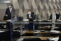 Senators Omar Aziz, left, Randolfe Rodrigues, center, and Renan Calheiros, attend a session by the commission investigating the government's management of the COVID-19 pandemic at the Federal Senate in in Brasilia, Brazil, Tuesday, Oct. 26, 2021. (AP Photo/Eraldo Peres)