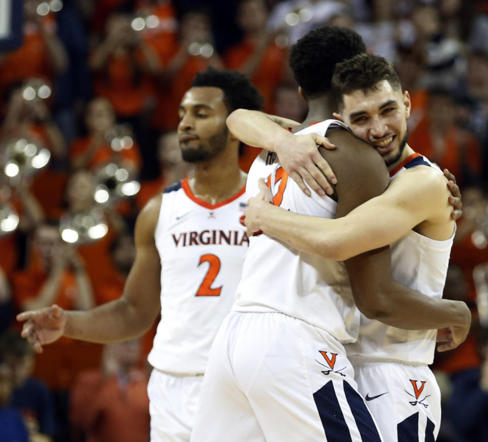 Virginia guard Ty Jerome, right, hugs Virginia guard De'Andre Hunter after an NCAA college basketball game against Louisville in Charlottesville, Va., Saturday, March 9, 2019. (AP Photo/Steve Helber)