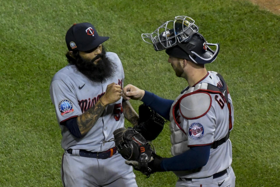 Minnesota Twins relief pitcher Sergio Romo, left, and catcher Mitch Garver, right, celebrate at end of a baseball game against the Chicago Cubs Sunday, Sept. 20, 2020, in Chicago. (AP Photo/Matt Marton)