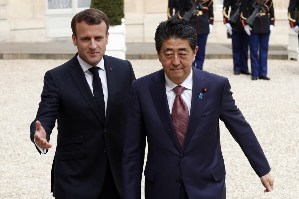 French President Emmanuel Macron, left welcomes Japan's Prime Minister Shinzo Abe wave before their talks at the Elysee Palace, Tuesday, April 23, 2019 in Paris. (AP Photo/Thibault Camus)