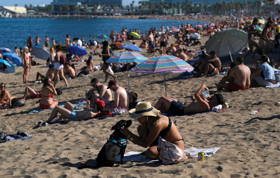 People enjoy the sunny weather at Barceloneta beach, after Catalonia's regional authorities and the city council announced restrictions to contain the spread of the coronavirus disease (COVID-19) in Barcelona, Spain July 19, 2020. REUTERS/Nacho Doce