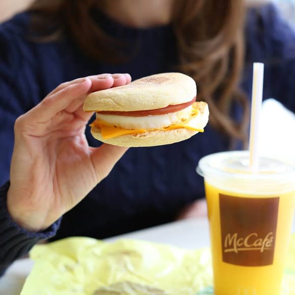 A customer holds a McDonald's breakfast sandwich.