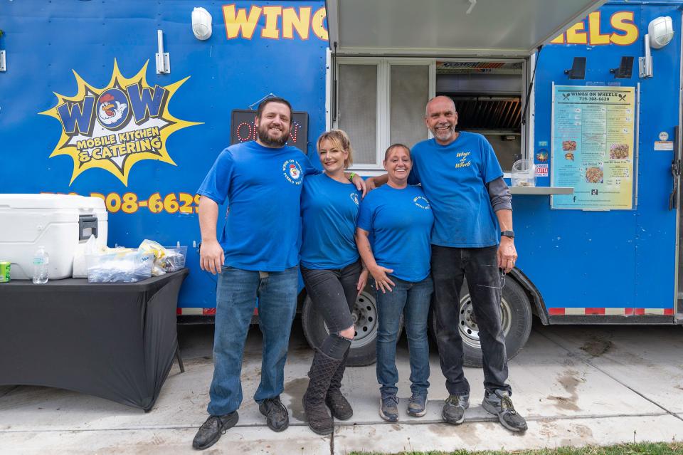 Steve and Nicole Stites, left, stand with owners Jennifer and Bryan Fahrer, right, outside the Wings on Wheels food truck at the Brew at the Zoo event on Saturday, April 27, 2024.