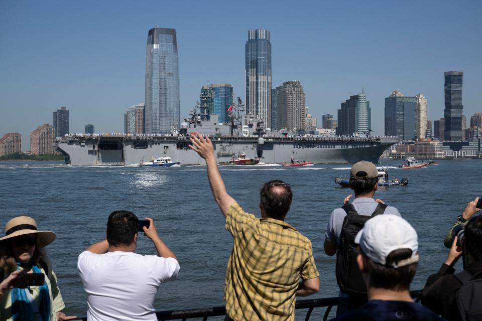 US Sailors and Marines stand on the flight deck of the USS Bataan, a Wasp-class amphibious assault ship, as it makes its way up the Hudson River during Fleet Week in New York Harbor on May 22, 2024.