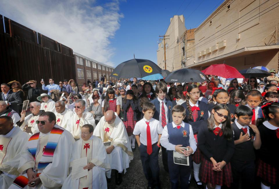 Hundreds gather to hear Boston Archdiocese Cardinal Sean O'Malley lead mass, Tuesday, April 1, 2014,along the international border wall in Nogales, Ariz. A delegation of Roman Catholic leaders celebrated Mass along the U.S.-Mexico border to raise awareness about immigration and to pray for policy changes. (AP Photo/Matt York)