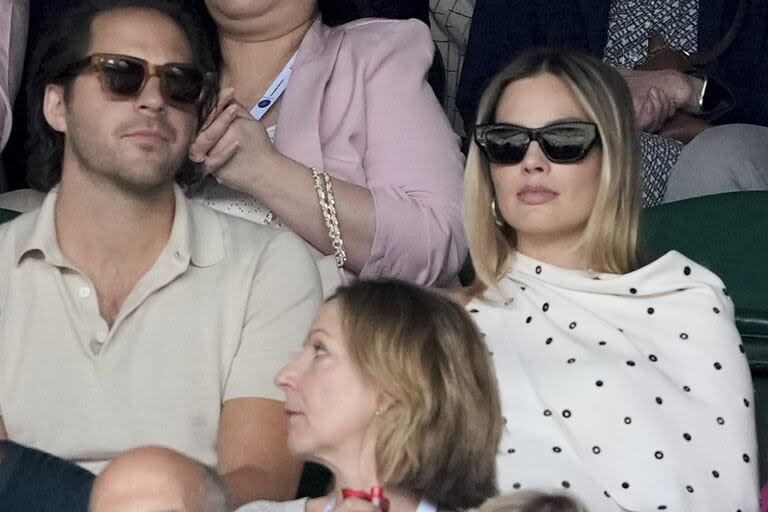 Felizmente embarazada, Margot Robbie presenció la semifinal de Wimbledon, en Londres, enfundada en un vestido blanco suelto y acompañada por su marido, el productor de cine Tom Ackerley