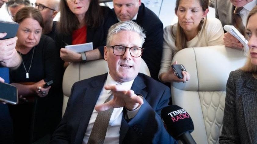 Prime Minister Sir Keir Starmer talks to journalists as he travels onboard a plane to Washington DC to attend a Nato summit.