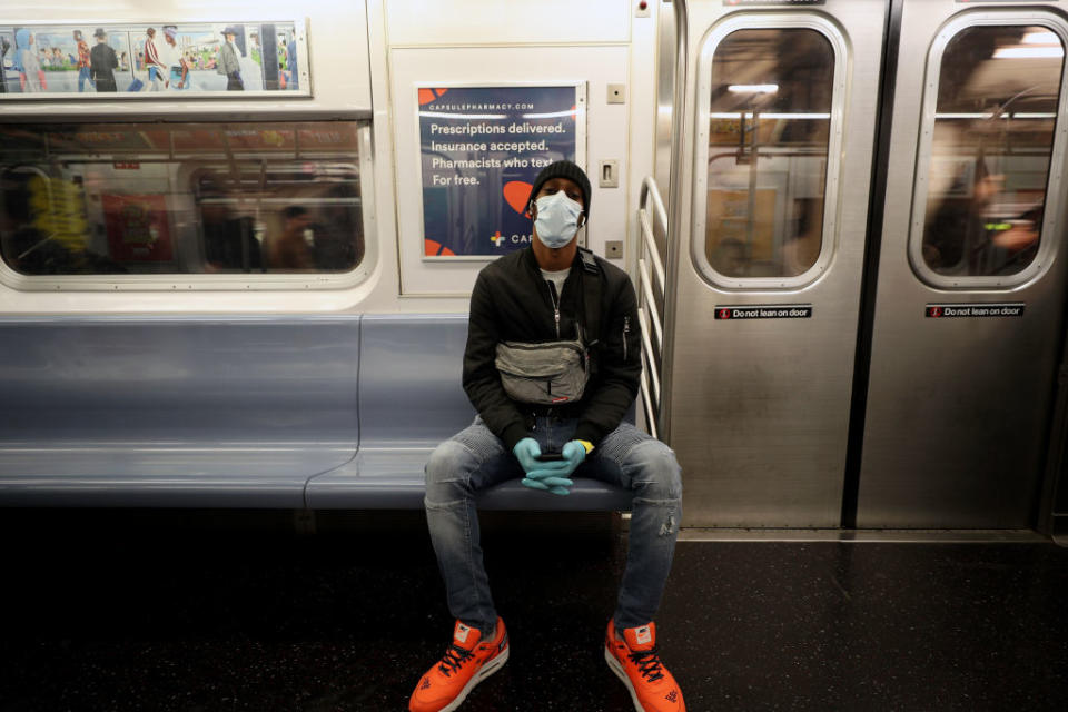 A man wears a face mask and surgical gloves to prevent Covid-19 spread on a New York City subway train. Source:  AP