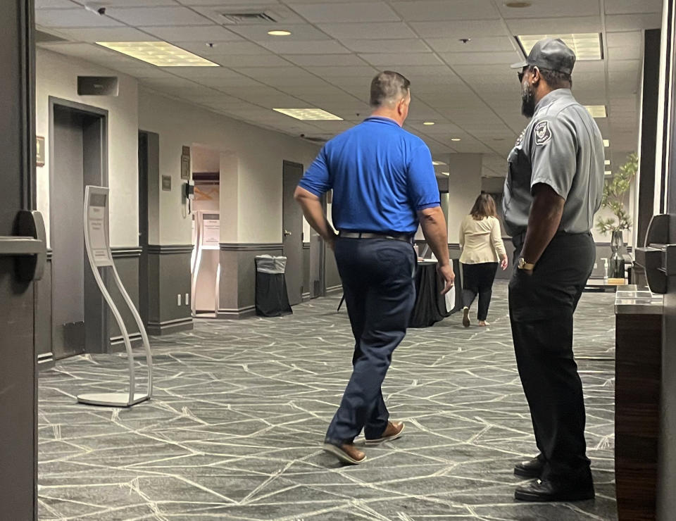 A security guard stands watch on Wednesday, July 20, 2022, at a gathering of the National Association of State Election Directors, which met under heightened security for its summer conference in Madison, Wisconsin. Organizers said they were working with federal, state and local law enforcement to ensure the gathering was safe, as election officials have faced increasing threats since the 2020 presidential election. (AP Photo/Harm Venhuizen)