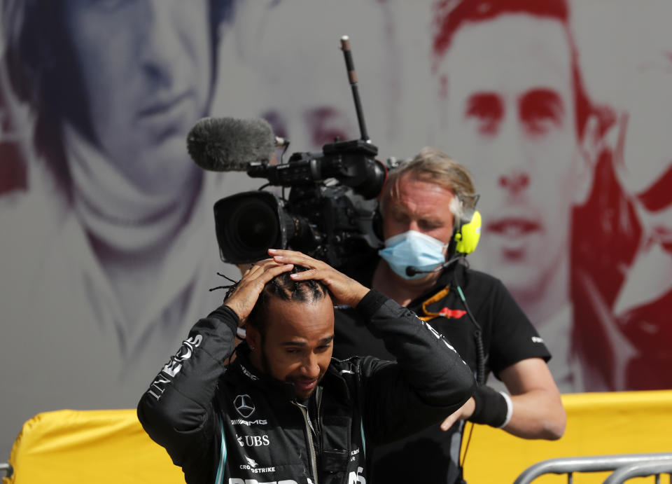 Race winner Mercedes driver Lewis Hamilton of Britain adjusts his hair after getting out of his car after the British Formula One Grand Prix at the Silverstone racetrack, Silverstone, England, Sunday, Aug. 2, 2020. (AP Photo/Frank Augstein, Pool)