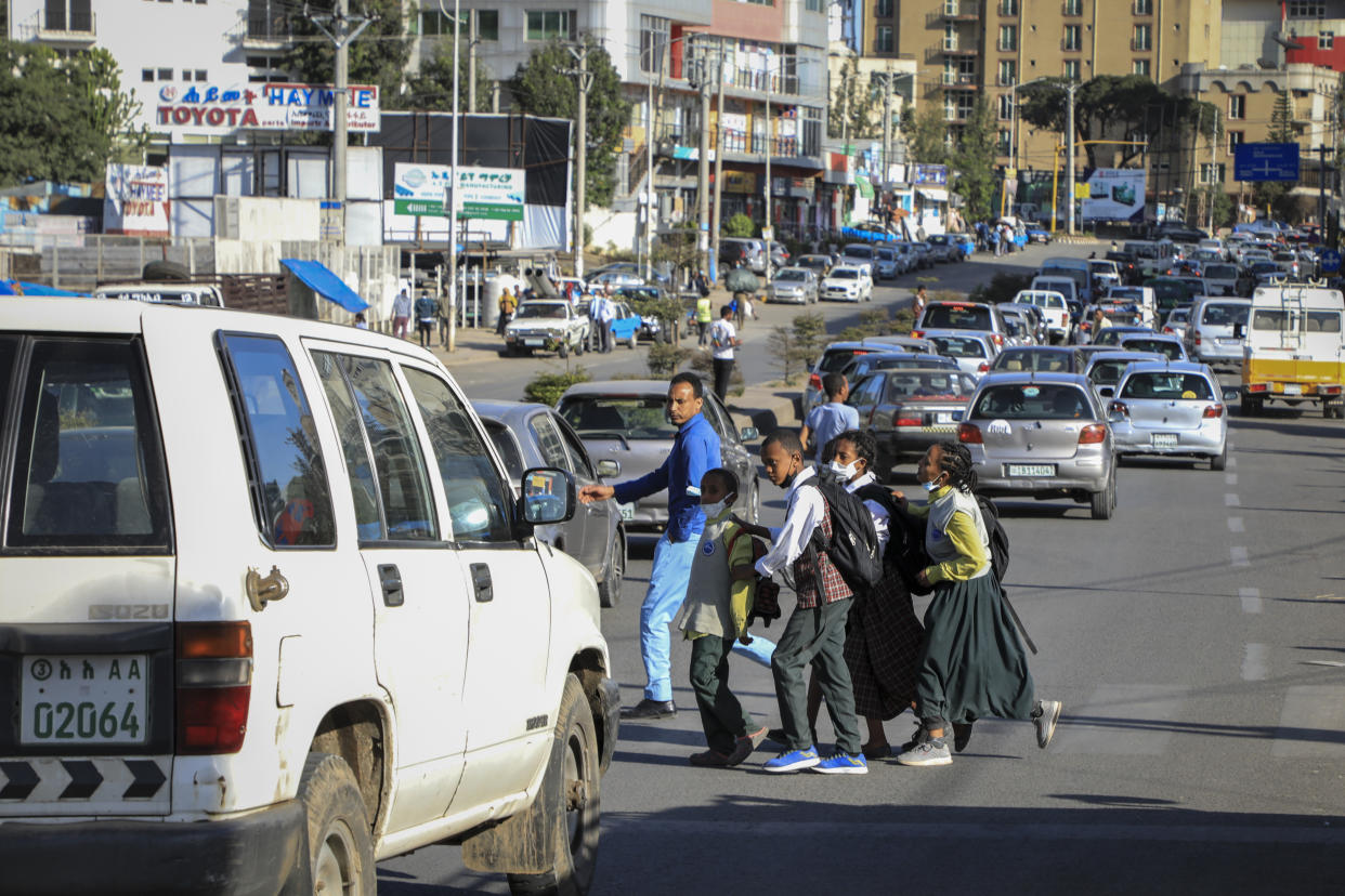Schoolchildren cross traffic as they return home from school in the Piazza old town area of the capital Addis Ababa, Ethiopia Thursday, Nov. 4, 2021. Urgent new efforts to calm Ethiopia's escalating war are unfolding Thursday as a U.S. special envoy visits and the president of neighboring Kenya calls for an immediate cease-fire while the country marks a year of conflict. (AP Photo)