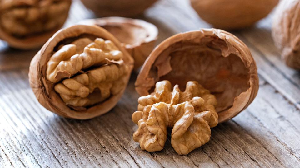 Walnut in shell sitting on wooden table