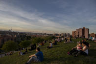 People sit in the Cerro del Tio Pio park in Madrid, Spain, Spain, Sunday, May 3, 2020. On Saturday, Spaniards were able to go outdoors to do exercise for the first time in seven weeks since the lockdown began to battle the coronavirus outbreak. (AP Photo/Manu Fernandez)