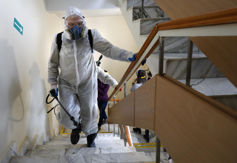 In this photo taken on Friday, Feb. 21, 2020, medic work to disinfect rooms in the sanatorium after quarantine period has ended in Bogandinsky in the Tyumen region, about 2150 kilometers (1344 miles) east of Moscow, Russia. 144 people who were evacuated from the epicenter of the CONVID-19 coronavirus outbreak in Wuhan, China, and were released from a 14-day quarantine in western Siberia. Russian authorities are going to great lengths to prevent the new coronavirus from spreading in the capital and elsewhere. (AP Photo/Maxim Slutsky)