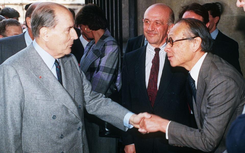 China-born US architect Ieoh Ming Pei (R) shaking hands with then French president Francois Mitterrand on the opening day of the Louvre museum pyramid - Credit: Getty