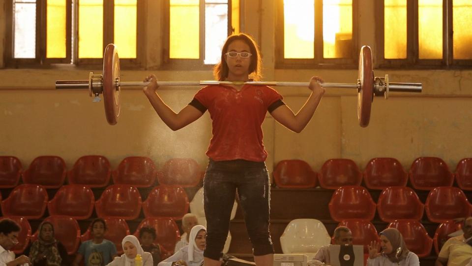 <p>Bringing true meaning to the phrase “fly-on-the-wall,” Mayye Zayed’s documentary spotlights the world of female weightlifting in Alexandria, Egypt, and the trials and tribulations faced by one team in their bid for success. Captain Ramadam is their leader, a former champion weightlifter who has trained up some of Egypt’s finest athletes to compete and succeed at Olympic level. His latest protégée is 14-year-old Zebibi, and over four years we see her grow-up and face mounting pressure from her aging coach as he struggles to get funding to improve his dilapidated gym.</p><p>It's an empowering film to show the obstacles women face to compete at the highest levels, especially in countries where they’re still dealing with gender and economic inequality. By assimilating the camera’s eye into the team and allowing the subjects to push the narrative forward as they train and contend with the complex bonds that bind them together, Zayyed serves up a human interest story of sincere heart and honesty.</p>