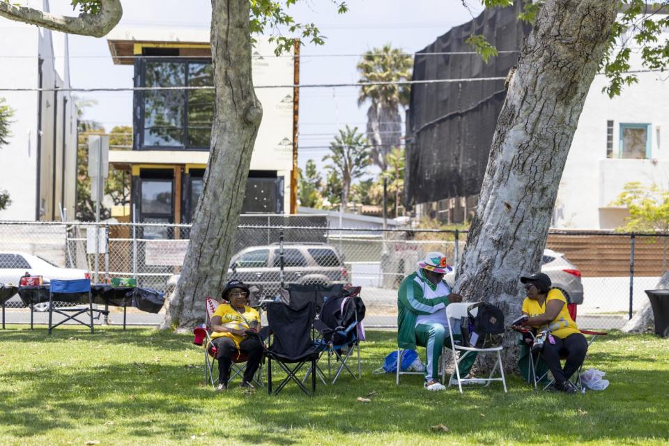 People sit on chairs on the grass