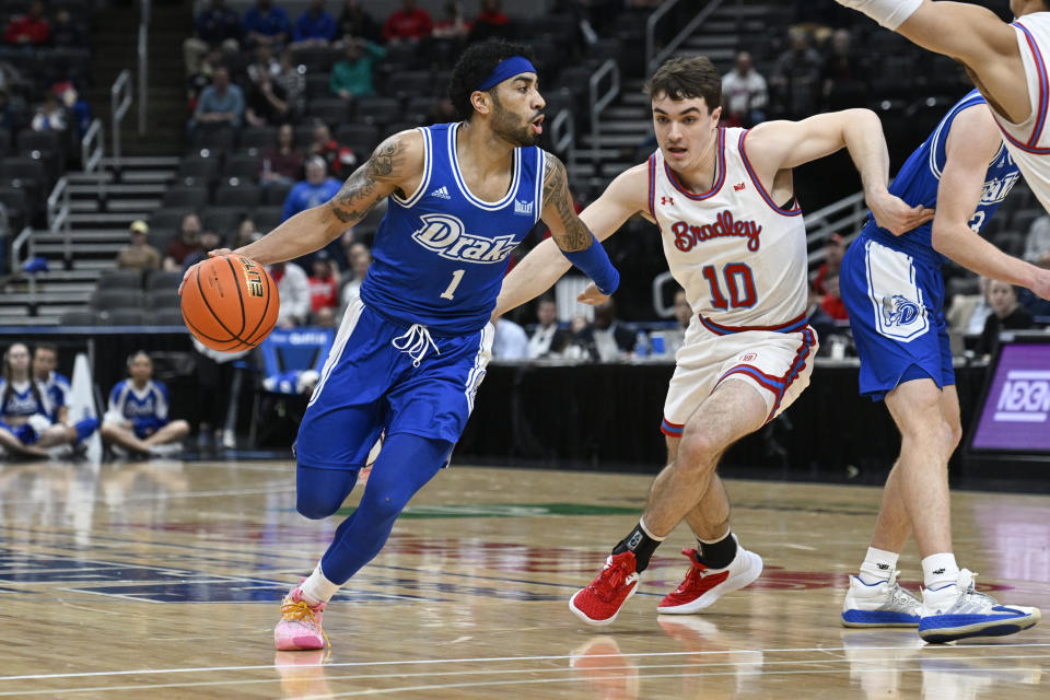 Drake guard Roman Penn (1) drives to the net as Bradley guard Connor Hickman (10) defends during the first half of the championship game in the MVC basketball tournament, Sunday, March 5, 2023, in St. Louis. (AP Photo/Joe Puetz)