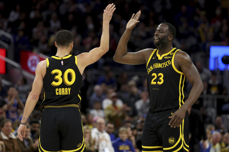 Golden State Warriors guard Stephen Curry (30) celebrates with forward Draymond Green (23) during the second half of an NBA basketball game against the Phoenix Suns in San Francisco, Saturday, Feb. 10, 2024. (AP Photo/Jed Jacobsohn)