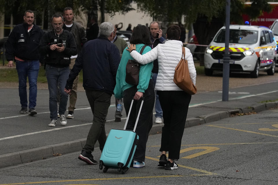 A schoolchildren leaves the Gambetta high school after a man armed with a knife killed a teacher and wounded two others in Arras, northern France, Friday, Oct. 13, 2023. A man of Chechen origin who was under surveillance by the French security services over suspected radicalization stabbed a teacher to death at his former high school and critically wounded two other people in northern France. (AP Photo/Michel Euler)