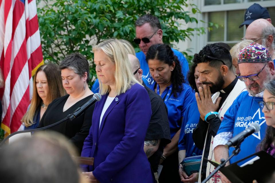 Highland Park Mayor Nancy Rotering, center, takes a moment of silence during a remembrance ceremony in Highland Park, Ill., Tuesday, July 4, 2023.   One year after a shooter took seven lives at the city's annual parade, community members are planning to honor the victims and reclaim the space to move forward.