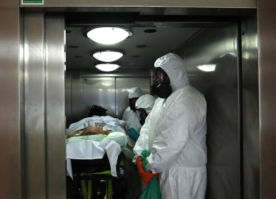 Health care workers transport a COVID-19 patient from an intensive care unit (ICU) at a hospital in Kyjov to hospital in Brno, Czech Republic, Thursday, Oct. 22, 2020. With cases surging in central Europe, some countries are calling in soldiers, firefighters, students and retired doctors to help shore up buckling health care systems. Many faced a shortage of medical personnel even before the pandemic, and now the virus has sickened many health workers, compounding the shortfall. (AP Photo/Petr David Josek)