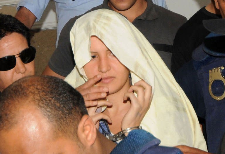 Amina Sboui (C), the Tunisian member of the Ukrainian feminist group Femen, appears handcuffed with a cloth over her head before an investigating judge at the courthouse of the central city Tunisian of Kairouan on June 5, 2013