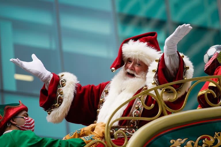 Santa Claus saluda mientras lo trasladan largo de la Sexta Avenida durante el Desfile del Día de Acción de Gracias de Macy's.