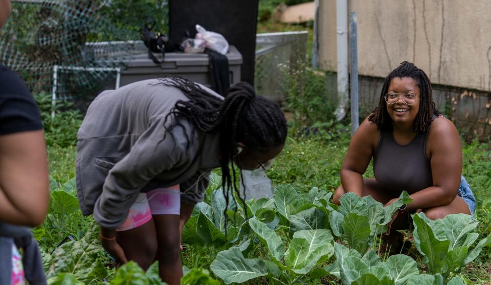 Danielle Guerin, right, works with some of her interns weeding vegetable plots and harvesting greens at her farm on the northeast side of Indianapolis, Wednesday, July 6, 2022. This Temple Avenue site is one of three urban gardens Guerin oversees under her own company, Soul Food Project Indy, which helps teach local young people about farming.