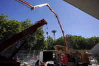 A crane and a cement pumping truck are shown with the Space Needle in the background as construction of the Climate Pledge Arena continues, Tuesday, Sept. 1, 2020, in Seattle, the home of the Seattle Kraken NHL hockey team. Sometime in the late summer or early fall of 2021, the Kraken will open the new facility -- at a cost that will likely total $1 billion by the time it's done -- and become the NHL's 32nd franchise. (AP Photo/Ted S. Warren)