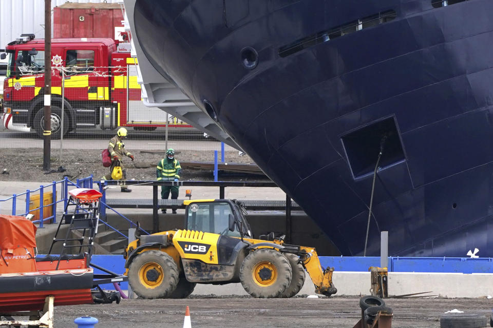 Emergency services work at Imperial Dock, where a ship has become dislodged from its holding and is partially toppled over, in Leith, Edinburgh, Scotland, Wednesday March 22, 2023. (Andrew Milligan/PA via AP)