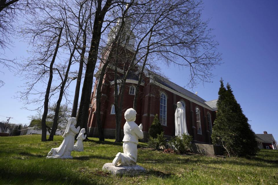 Statues of nuns and a boy praying stand outside Holy Family Catholic Church, Friday, April 28, 2023, in Old Town, Maine. Robert Dupuis, of East Lyme, Conn., says he was abused as a boy at the church when it was known as St. Joseph Catholic Church. (AP Photo/Robert F. Bukaty)