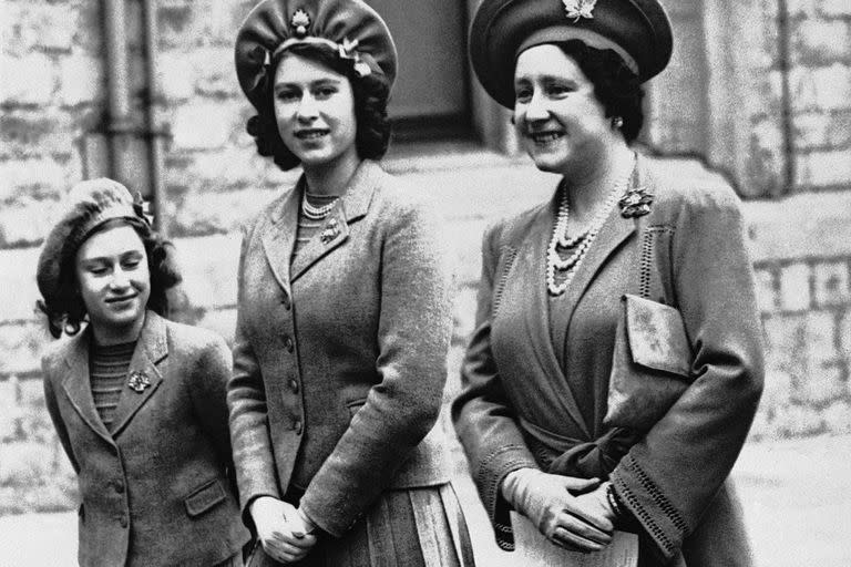 La princesa Isabel de 16 años (centro) junto a su madre la reina Isabel y su hermana menor la princesa Margarita mientras caminan hacia el patio de armas del Castillo de Windsor para una revisión de la Guardia de Granaderos, el 19 de mayo de 1942