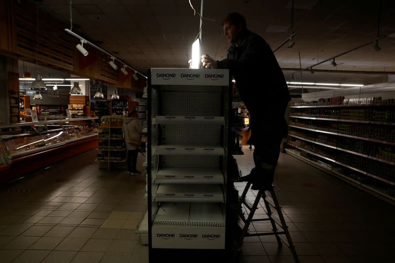 FILE PHOTO: People shop during an electricity outage, in Kharkiv