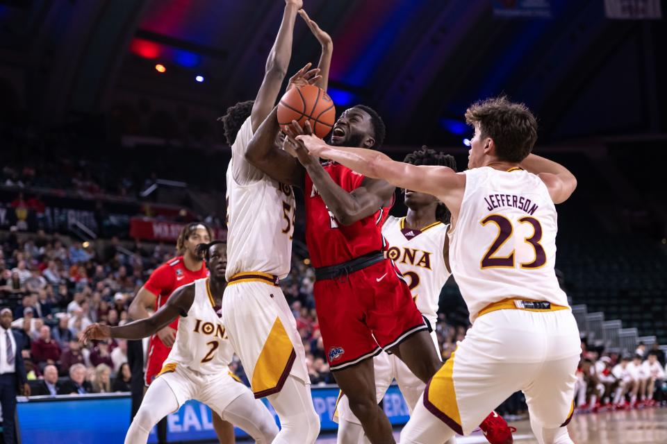 Iona's Osborn Shema (55, left) and Michael Jefferson (23, right) pressure Marist's Noah Harris during the first half of the MAAC Tournament finals at Jim Whelan Boardwalk Hall on March 11, 2023.
