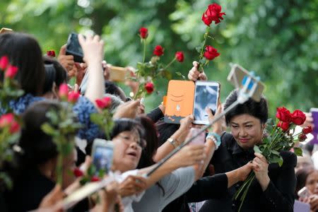 Ousted former Thai prime minister Yingluck Shinawatra greets supporters as she arrives at the Supreme Court in Bangkok, Thailand July 21, 2017. REUTERS/Chaiwat Subprasom