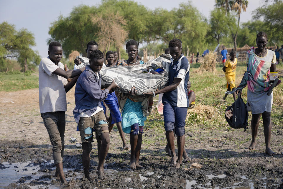 Villagers use a mat to carry a sick woman to a boat operated by the International Medical Corps to take her to a nearby town, as the area has limited access to healthcare and few roads, in Canal-Pigi county, South Sudan Saturday, May 7, 2023. More than 40,000 people, mostly South Sudanese, have crossed the border into South Sudan since Sudan erupted in conflict nearly one month ago, yet many are returning to areas unable to support them and still riddled by fighting. (AP Photo/Sam Mednick)