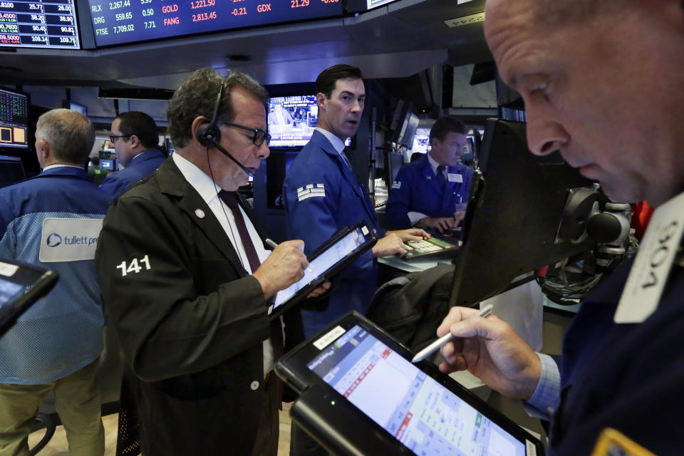 Specialist John McNierney, background center, works with traders Sal Suarino, left, and Michael Urkonis, right, on the floor of the New York Stock Exchange, Monday, July 30, 2018. Stocks are off to a mixed start on Wall Street as gains in banks and energy companies are offset by losses in other sectors. (AP Photo/Richard Drew)