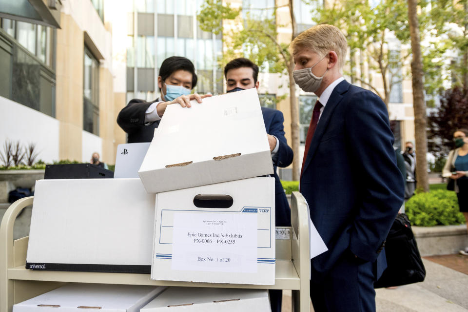 Members of Epic Games' legal team roll exhibit boxes into the Ronald V. Dellums building in Oakland, Calif., for the company's lawsuit against Apple on Monday, May 3, 2021. Epic, maker of the video game Fortnite, charges that Apple has transformed its App Store into an illegal monopoly. (AP Photo/Noah Berger)